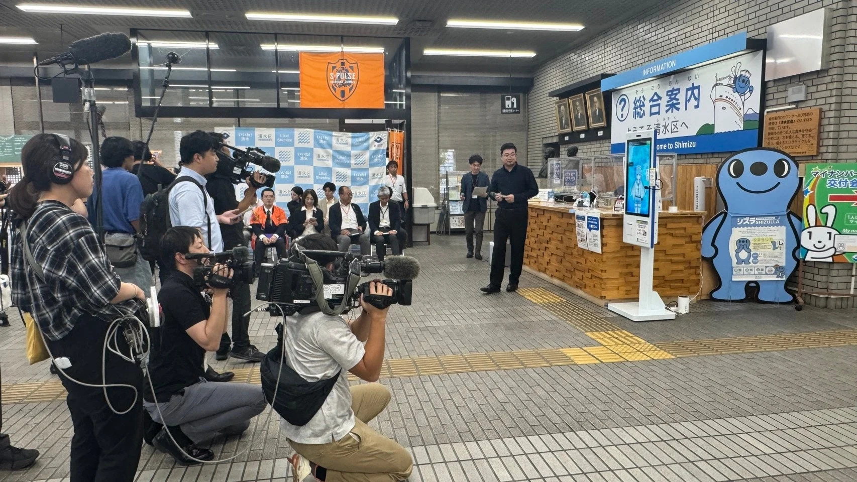 情報案内所前で報道陣が集まる様子