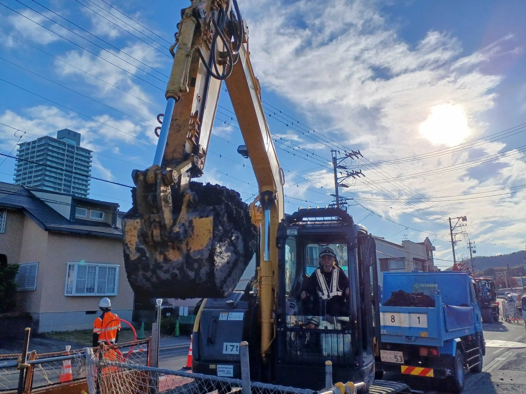 建設現場で油圧ショベルが土砂を運ぶ様子