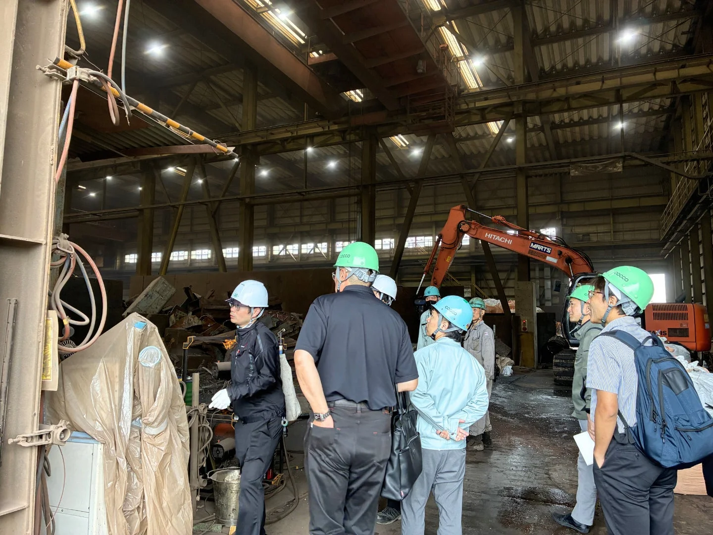 工場で作業現場を視察する人々