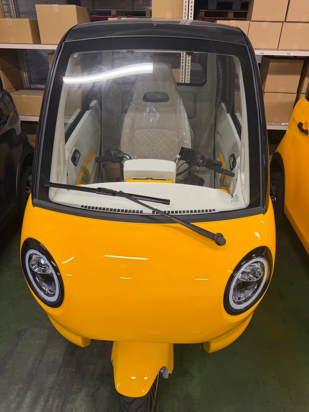 黄色の三輪小型モビリティ、倉庫内