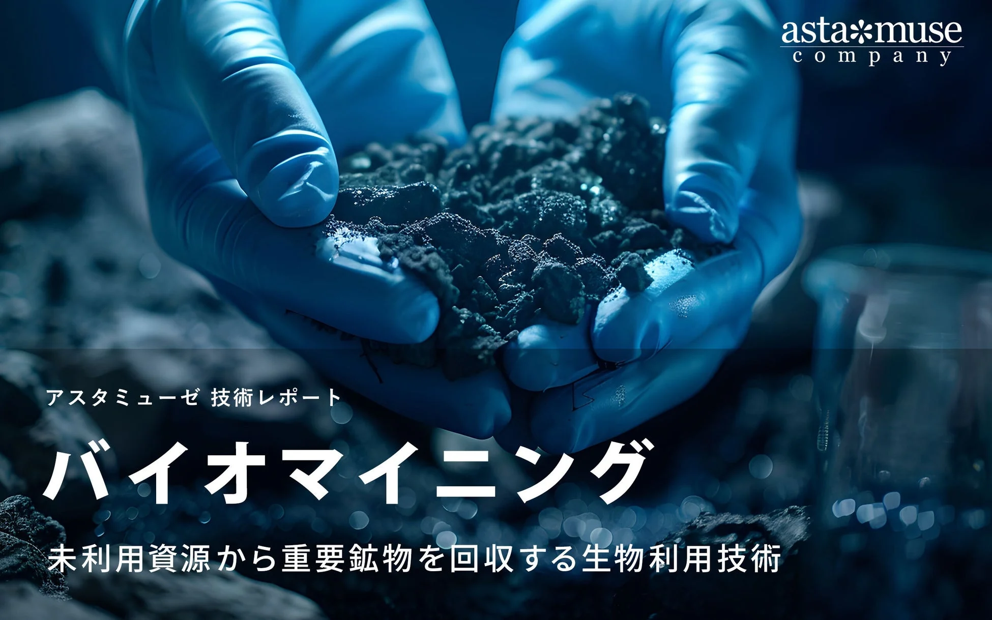 青いグローブの手が暗い粒状の物質を持つ画像