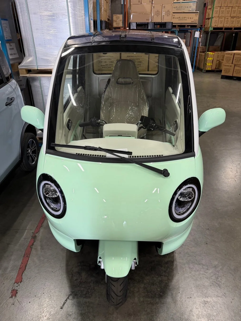 ミントグリーンの三輪電動自動車、倉庫内