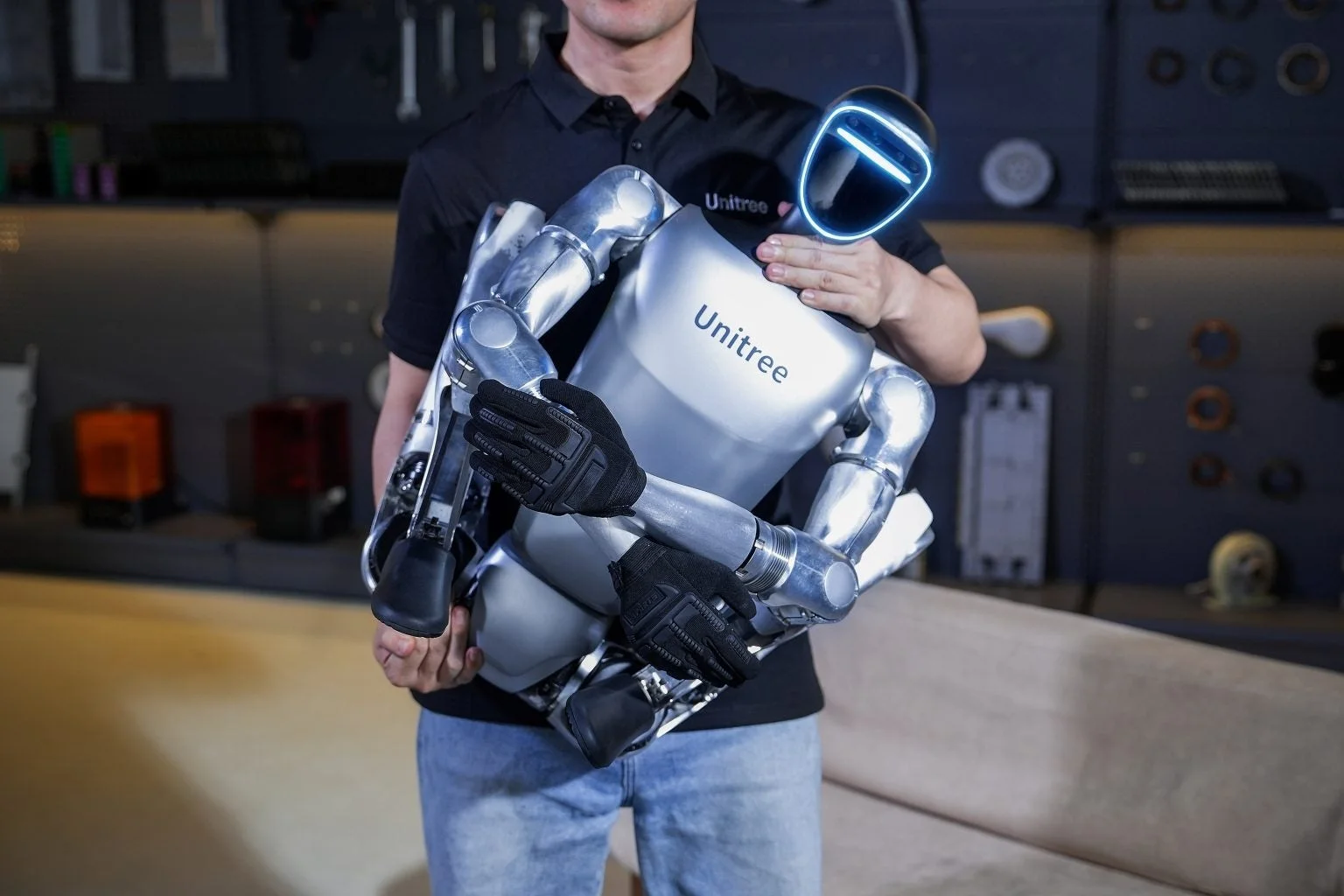 人型ロボットを抱える人物