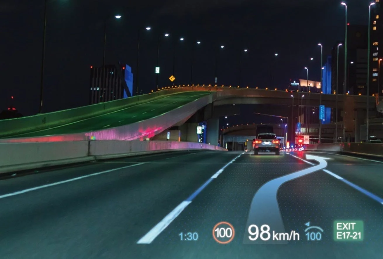 夜の高速道路を走行中の車内から見た光景。拡張現実（AR）ナビゲーションシステムが路面に次の経路、速度、速度制限、出口情報などを表示
