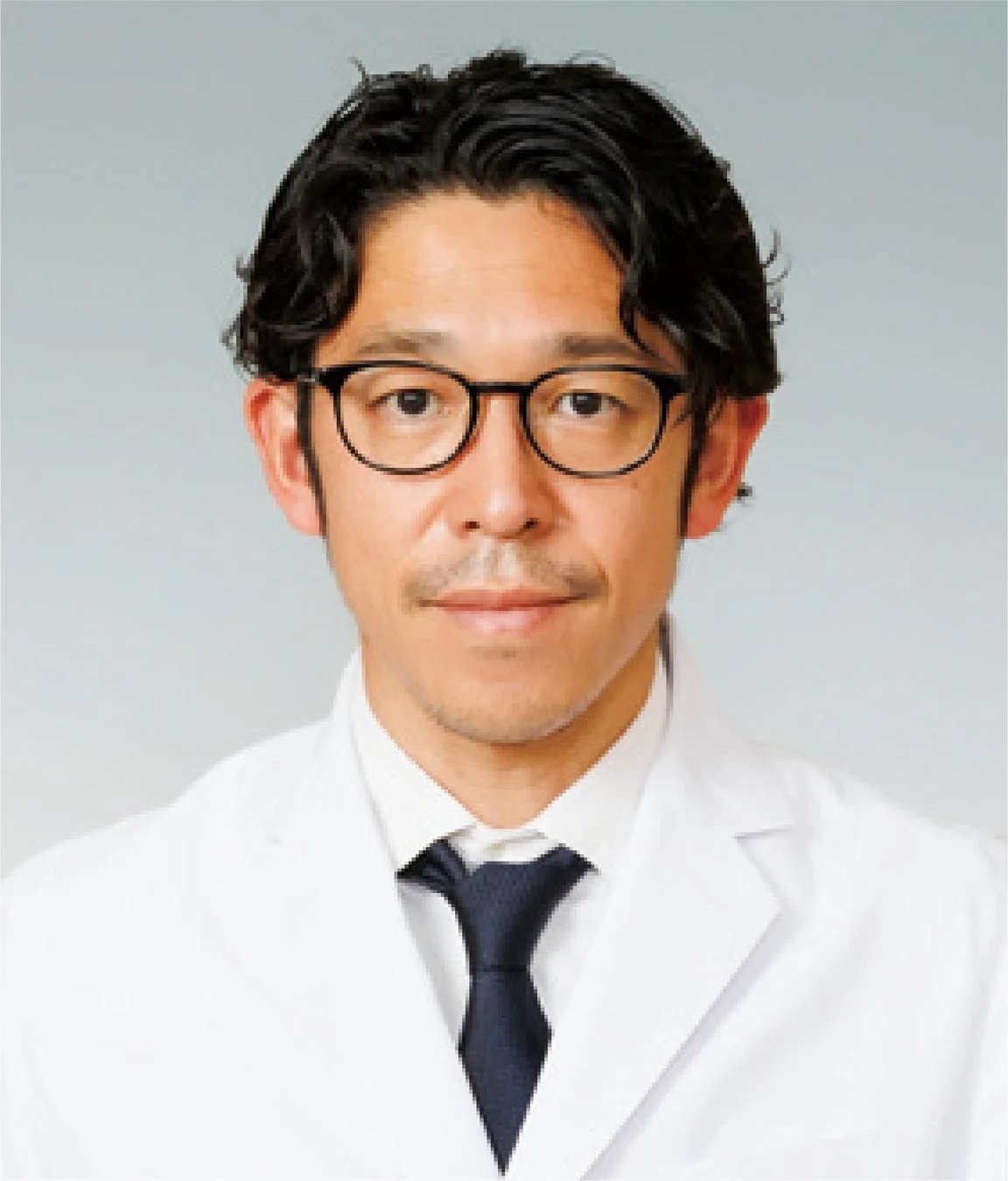 白衣を着用し、眼鏡をかけた日本人男性のポートレート