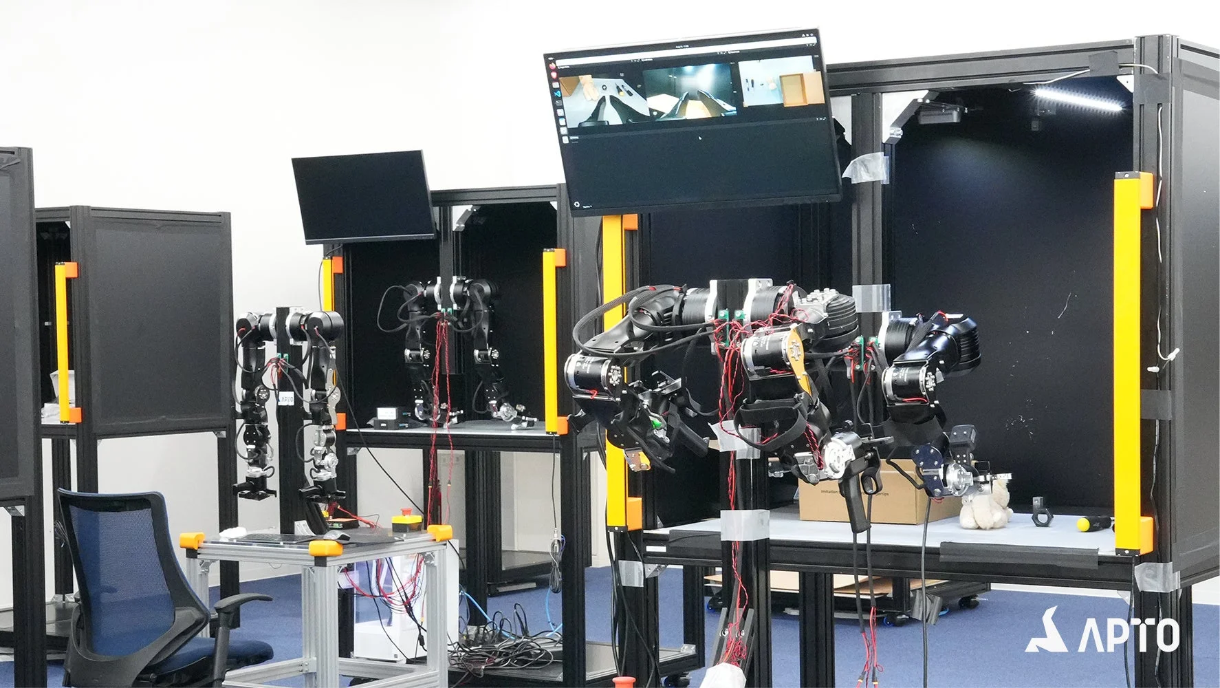 ロボットアームが複数設置された現代的な研究室または作業場の様子