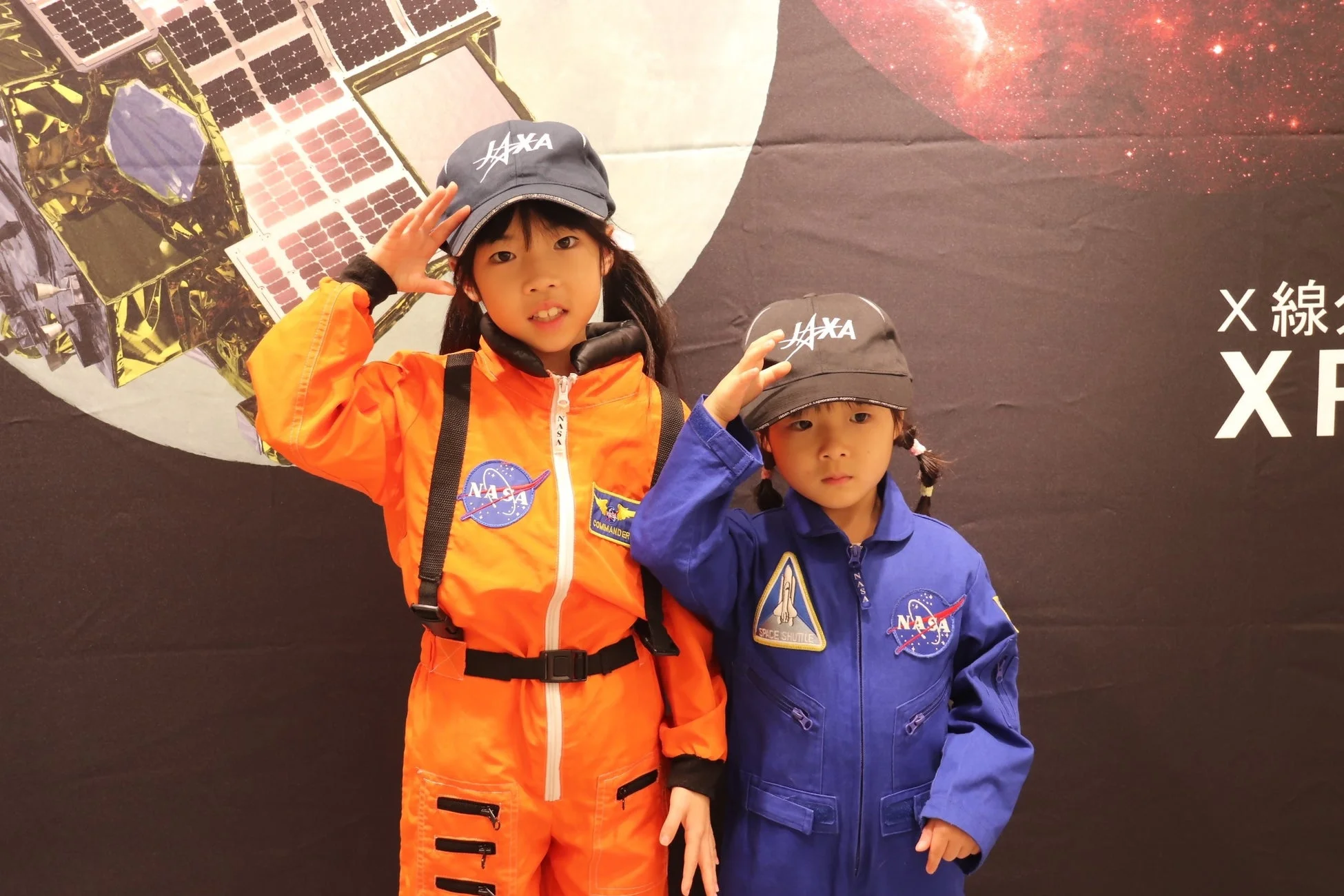 宇宙服を着て敬礼する子供たち