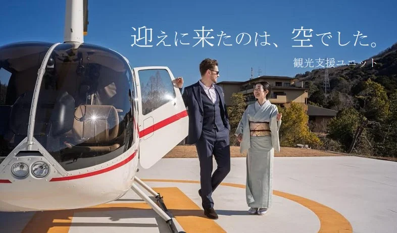 ヘリポートでヘリコプターの傍らに立つ人々