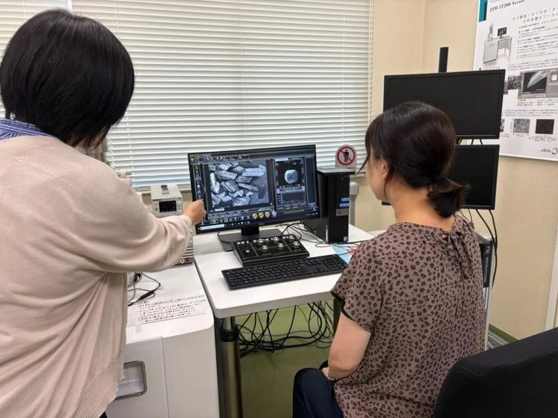 研究室でコンピューターを囲む女性たち