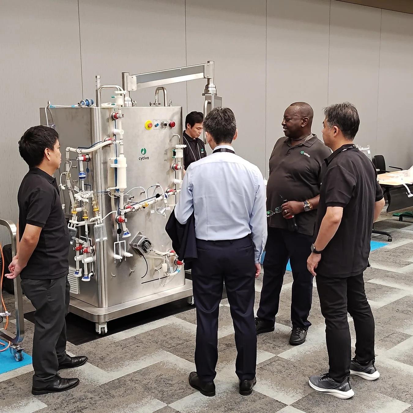 バイオ医薬品製造装置を囲んで議論する参加者