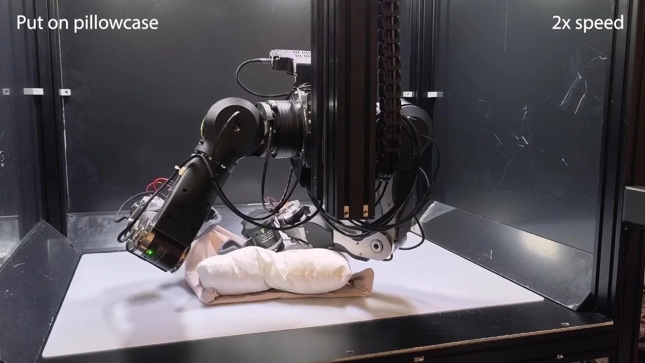 ロボットアームが枕に枕カバーを装着する様子