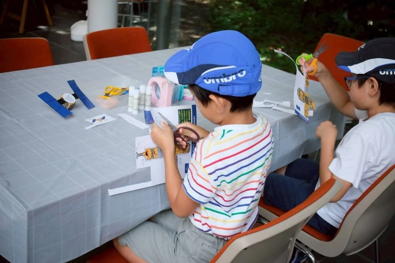 子供たちがJAXAロケットのペーパークラフトを作る様子